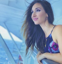 a young woman leaning on the railing of a cruise ship